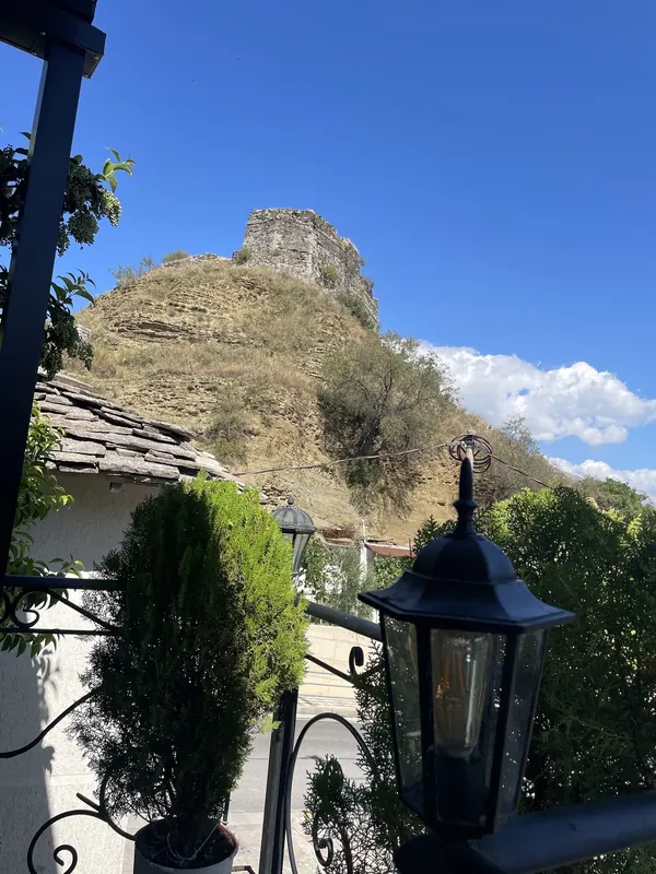 Gjirokastër Castle on its hill under a blue sky, seen from the restaurant terrace