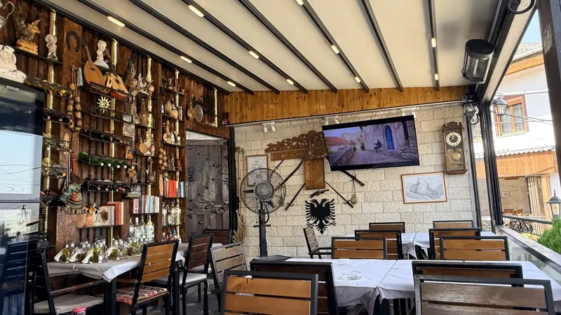 The dining room with white tablecloths, stone walls and the Albanian eagle